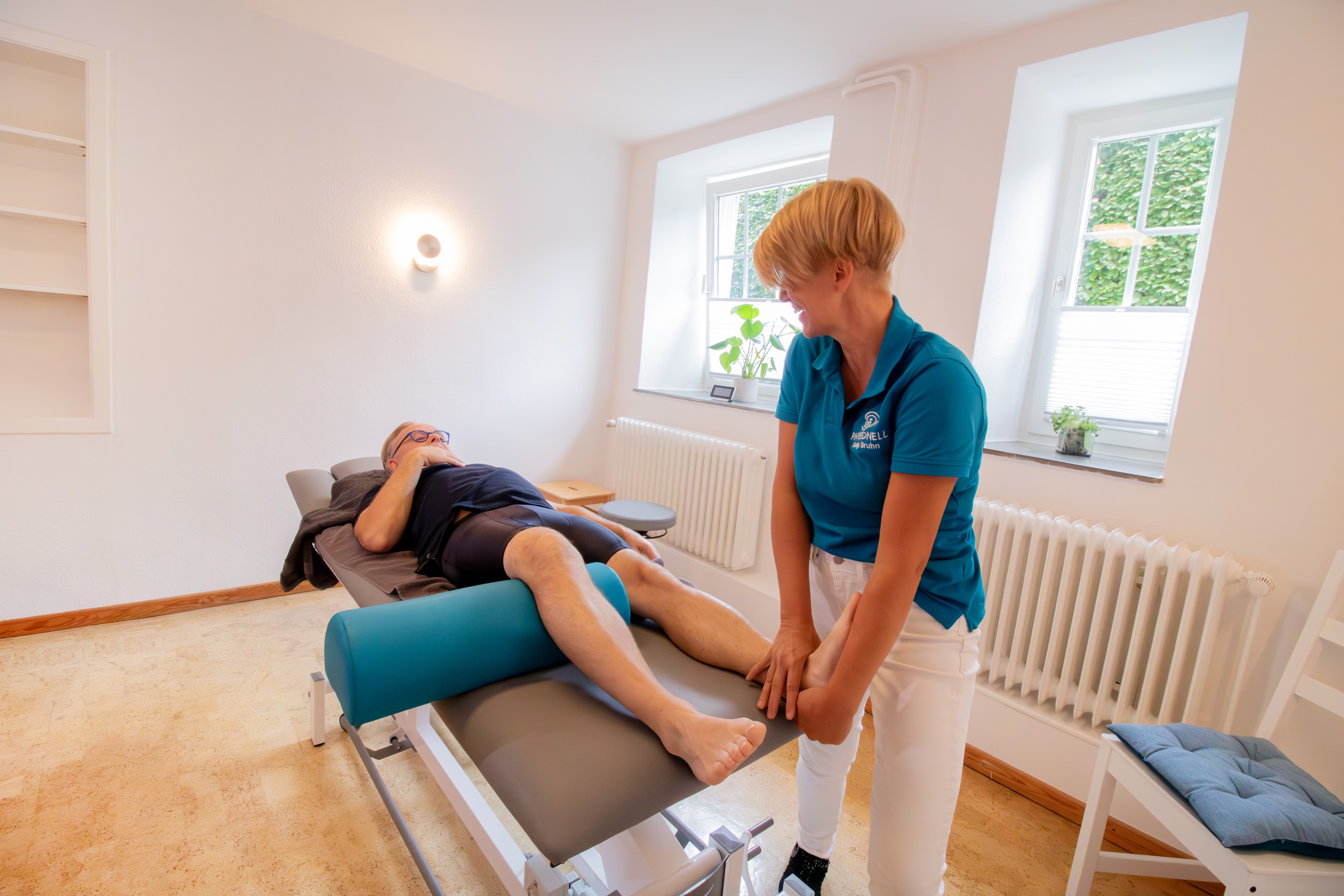 Manuelle Therapie (MT) / Orthopädische Manuelle Therapie (OMT) Physiotherapeutin Julia Neelsen behandelt den Rücken eines Patienten.
